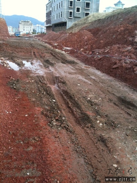 栖霞中路损坏的路基垫层和正在路面施工车辆.jpg